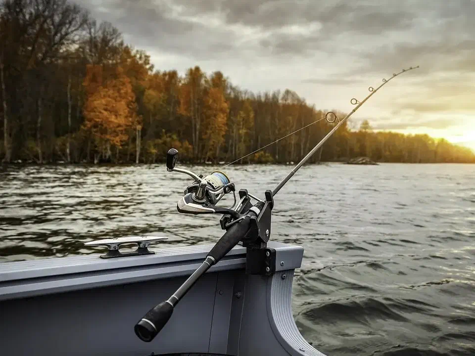 Canne à pêche sur un bateau au coucher du soleil
